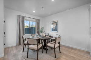Dining area with light wood-style flooring and recessed lighting
