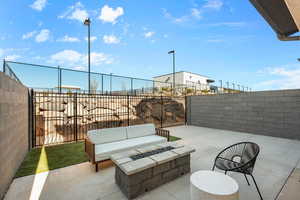 Fenced backyard with a patio area and an outdoor living space with a fire pit