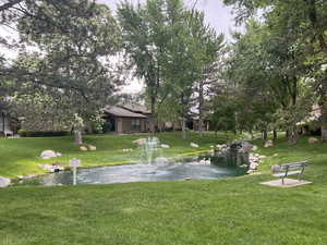 View of home's community with a lawn and a water view