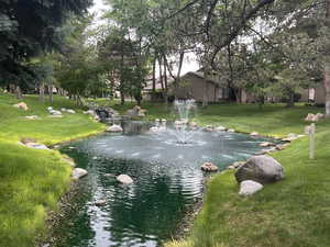 View of community featuring a yard and a water view