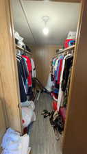 Walk in closet with light wood-type flooring