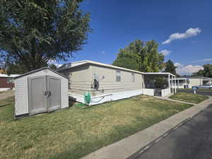 View of front of home featuring a front lawn and a shed