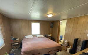Bedroom featuring wooden walls and wood finished floors