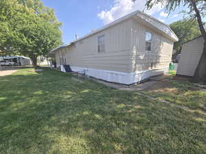 View of property exterior with a yard and a shed