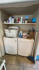 Laundry area with light tile patterned flooring and washing machine and dryer