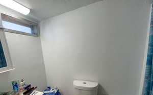 Bathroom with a textured wall and a textured ceiling