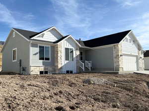 View of front facade featuring stone siding and an attached garage