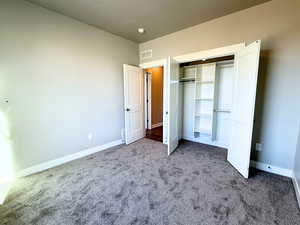 Unfurnished bedroom with carpet flooring and a closet