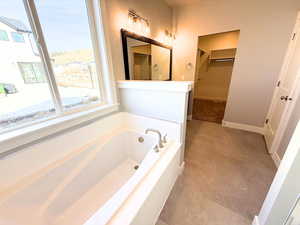 Bathroom with a bath and a spacious closet