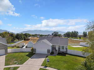 Ranch-style home with concrete driveway, a mountain view, and an attached garage