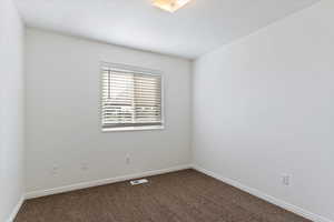Empty room featuring carpet floors and baseboards