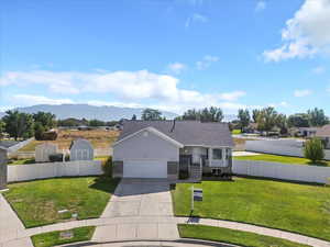 Ranch-style house with concrete driveway, a garage, and a mountain view