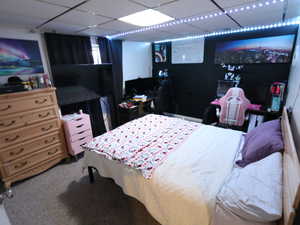 Bedroom featuring a paneled ceiling and carpet floors