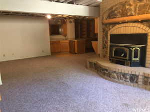 Unfurnished living room with light colored carpet and a fireplace