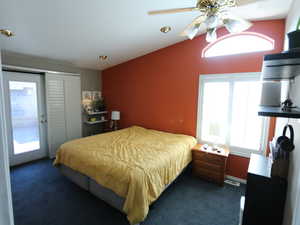 Bedroom with access to exterior, a ceiling fan, and dark colored carpet