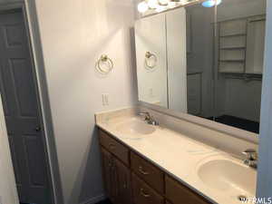 Bathroom featuring double vanity and baseboards