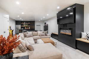 Living area featuring recessed lighting, bar area, a large fireplace, and light colored carpet