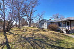 View of green lawn featuring a porch