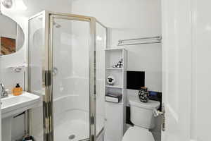 Bathroom with a shower stall and toilet