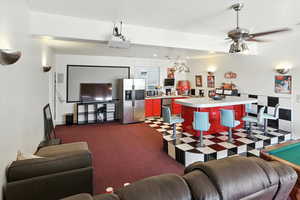 Living room with dark carpet and ceiling fan