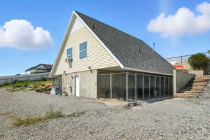 Back of property featuring roof with shingles