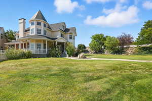 Victorian-style house with covered porch and a front lawn
