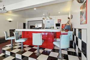 Kitchen with recessed lighting, light countertops, dark flooring, and freestanding refrigerator
