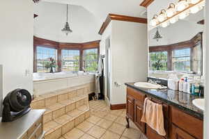 Bathroom featuring double vanity, a jetted tub, light tile patterned flooring, a shower stall, and lofted ceiling