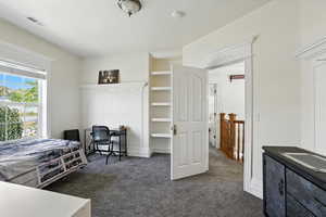 Bedroom featuring dark carpet