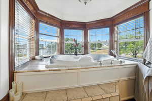 Full bath featuring a bath and light tile patterned flooring