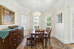 Dining room with ornamental molding, plenty of natural light, and a chandelier