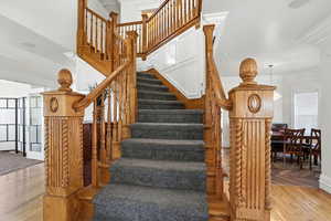 Staircase featuring crown molding and wood finished floors