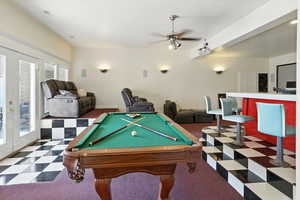 Playroom featuring french doors, pool table, ceiling fan, and dark colored carpet