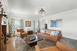 Living room with arched walkways and ornamental molding