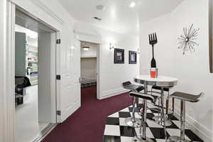 Dining room with dark carpet and recessed lighting