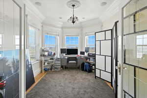 Home office with ornamental molding, light carpet, and a chandelier