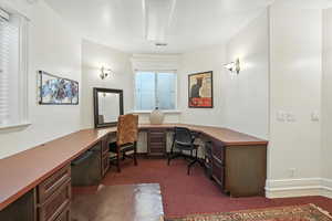 Built in Office featuring built in desk and dark carpet