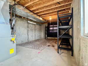 Unfinished below grade area featuring heating unit
