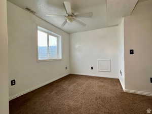 Carpeted spare room featuring a textured ceiling and ceiling fan