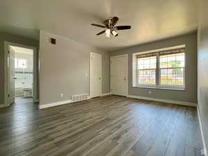 Unfurnished bedroom featuring wood finished floors, a ceiling fan, and ensuite bath