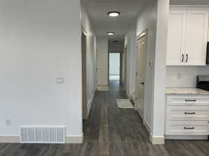 Hallway with baseboards and dark wood-type flooring