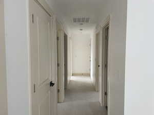 Hall featuring light colored carpet