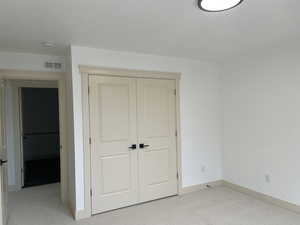 Unfurnished bedroom with light carpet and a closet