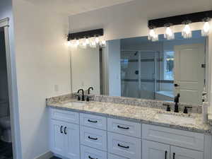 Full bath with a shower stall, a garden tub, and double vanity