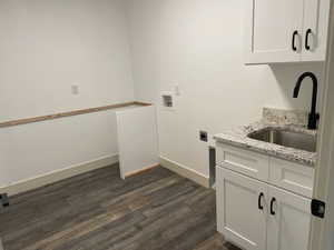 Washroom featuring cabinet space, dark wood finished floors, hookup for a washing machine, and electric dryer hookup