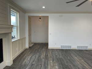Unfurnished dining area with ornamental molding, dark wood-style floors, a fireplace, recessed lighting, and a ceiling fan