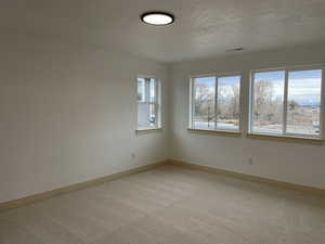 Spare room featuring baseboards and light colored carpet
