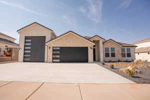 View of front facade with an attached garage, concrete driveway, stucco siding, and a tiled roof