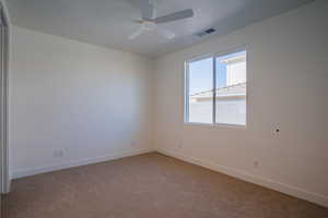 Empty room with light carpet and a ceiling fan