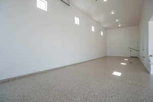 Unfurnished room with speckled floor and baseboards